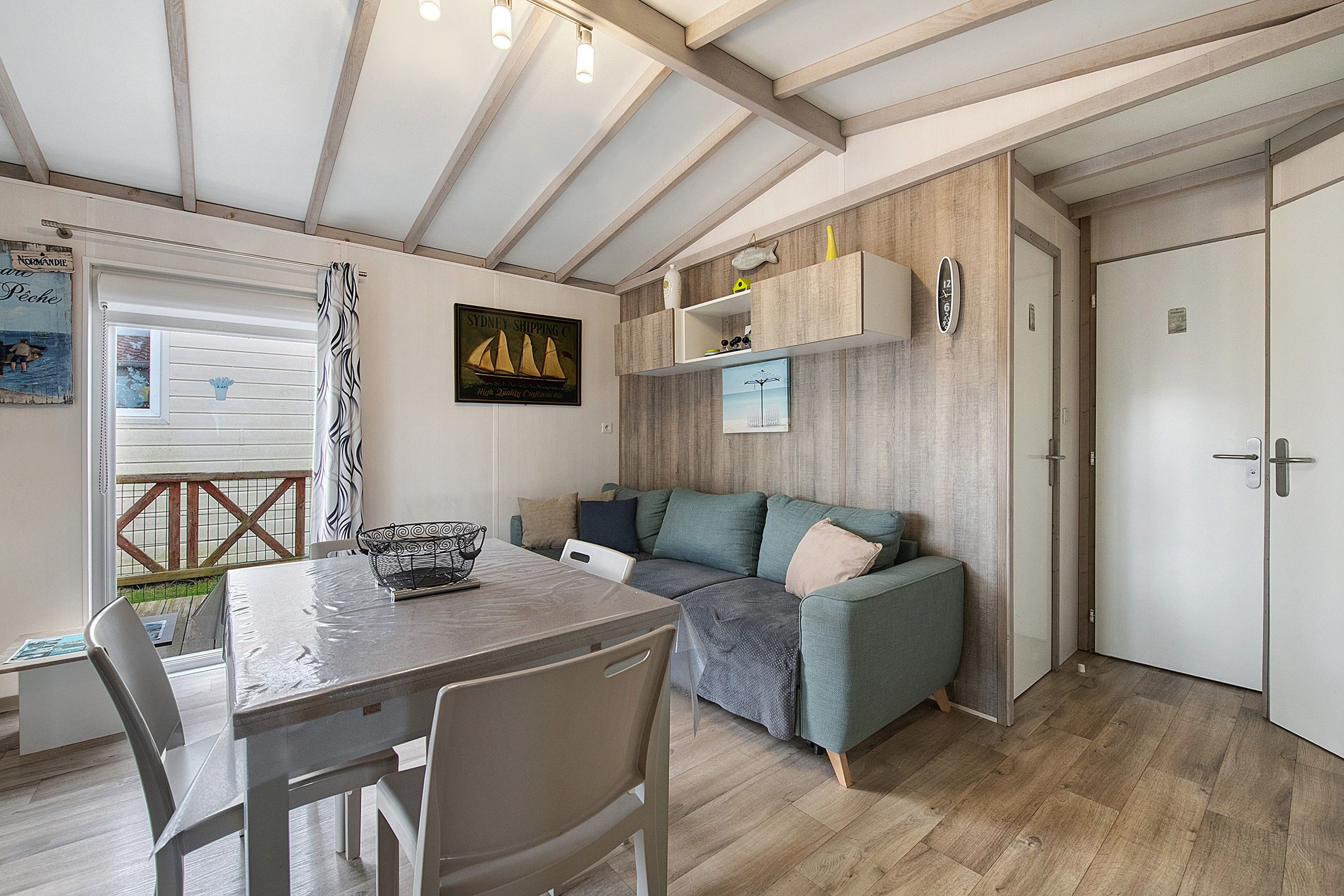 A cozy room with a dining table, chairs, a sofa, and a wooden floor.