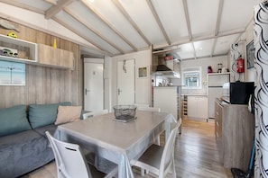 Un espace de vie compact comprenant un coin repas, une kitchenette et un canapé.