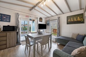 Een knus interieur met een eethoek, een bank en een televisie.
