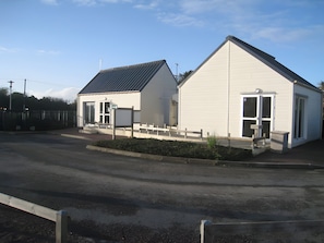 A two-story building with a flat roof, a front entrance, and a small porch area.