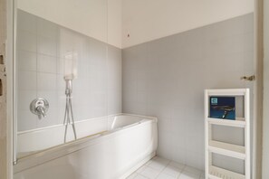 A bathroom with a bathtub, a shower, and a white tiled wall. - Spacious 200 sqm apartment, ideal for groups of up to 8 people, located on the 2nd floor of a building with an elevator.The property is centrally located, just a 7-minute walk from the San Babila M1 metro stop and a 14-minute walk from the Duomo.Essent (Milan)