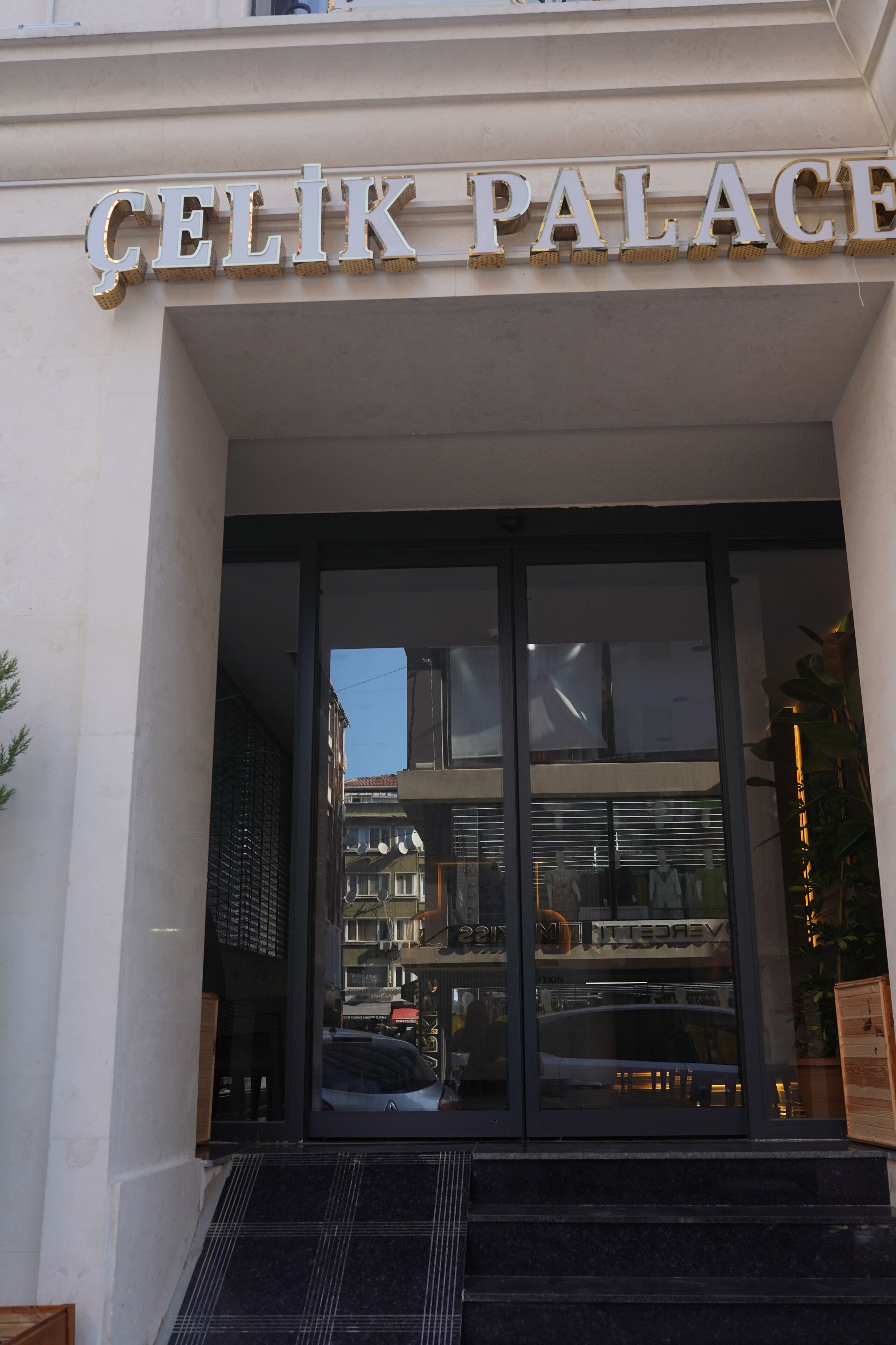 La entrada a un edificio con un letrero que dice 'CELIK PALACE'.