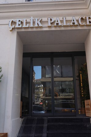 La entrada a un edificio con un letrero que dice 'CELIK PALACE'.