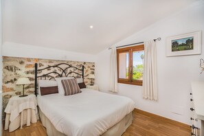 A bedroom with a bed, a nightstand, a lamp, a window with curtains, and a wall-mounted picture. - Caseta DE Lloseta Ref Vp22 1 (Lloseta)