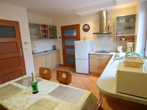 A compact kitchen with a refrigerator, a microwave, and a dining area with a table set for two.