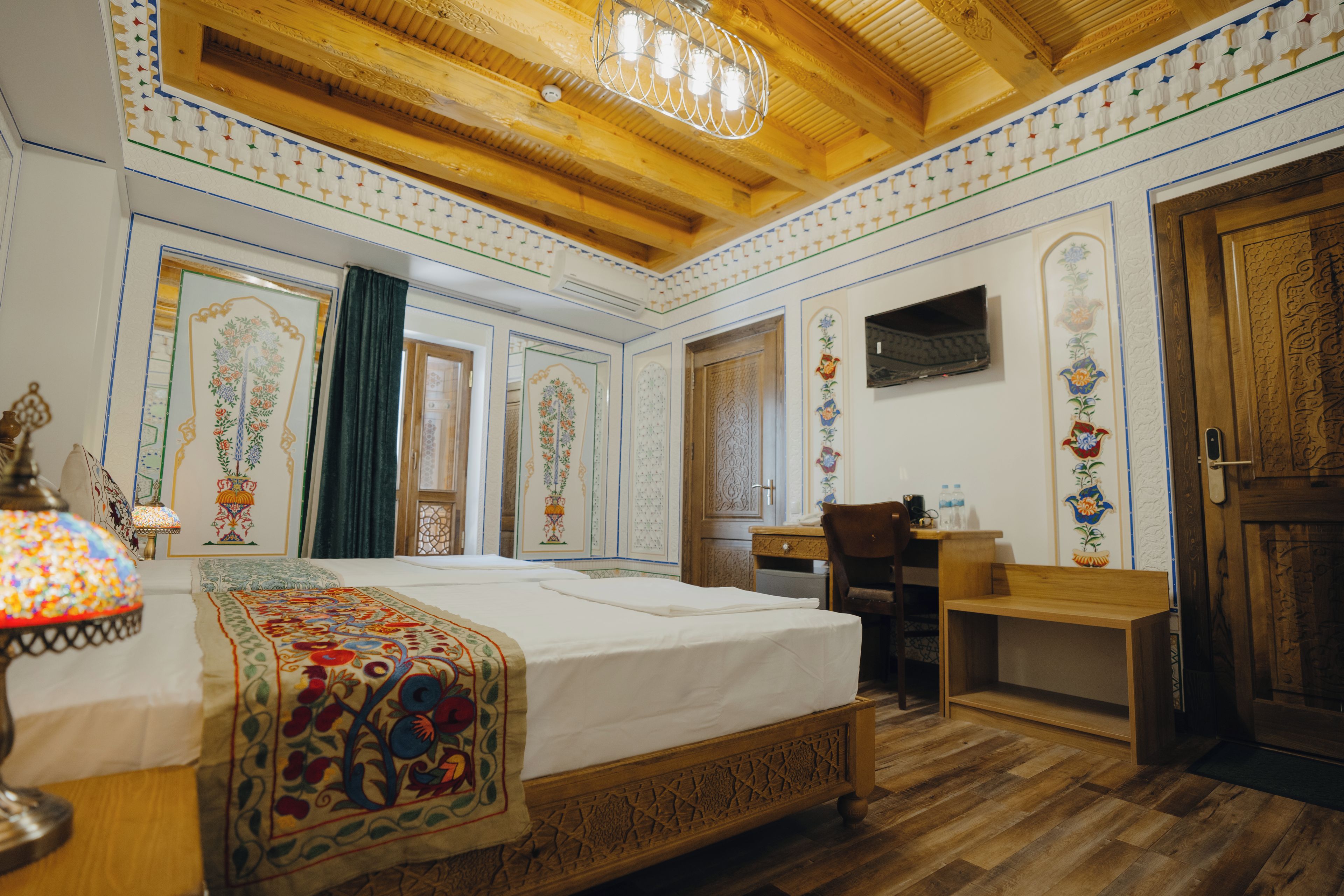 Ein traditionell eingerichteter Raum mit einem Bett, Schreibtisch und Fernseher.