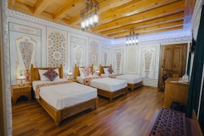 A traditional room with three wooden beds, a wooden ceiling, and decorative wall panels. - Imranbek Boutique Hotel (Bukhara)