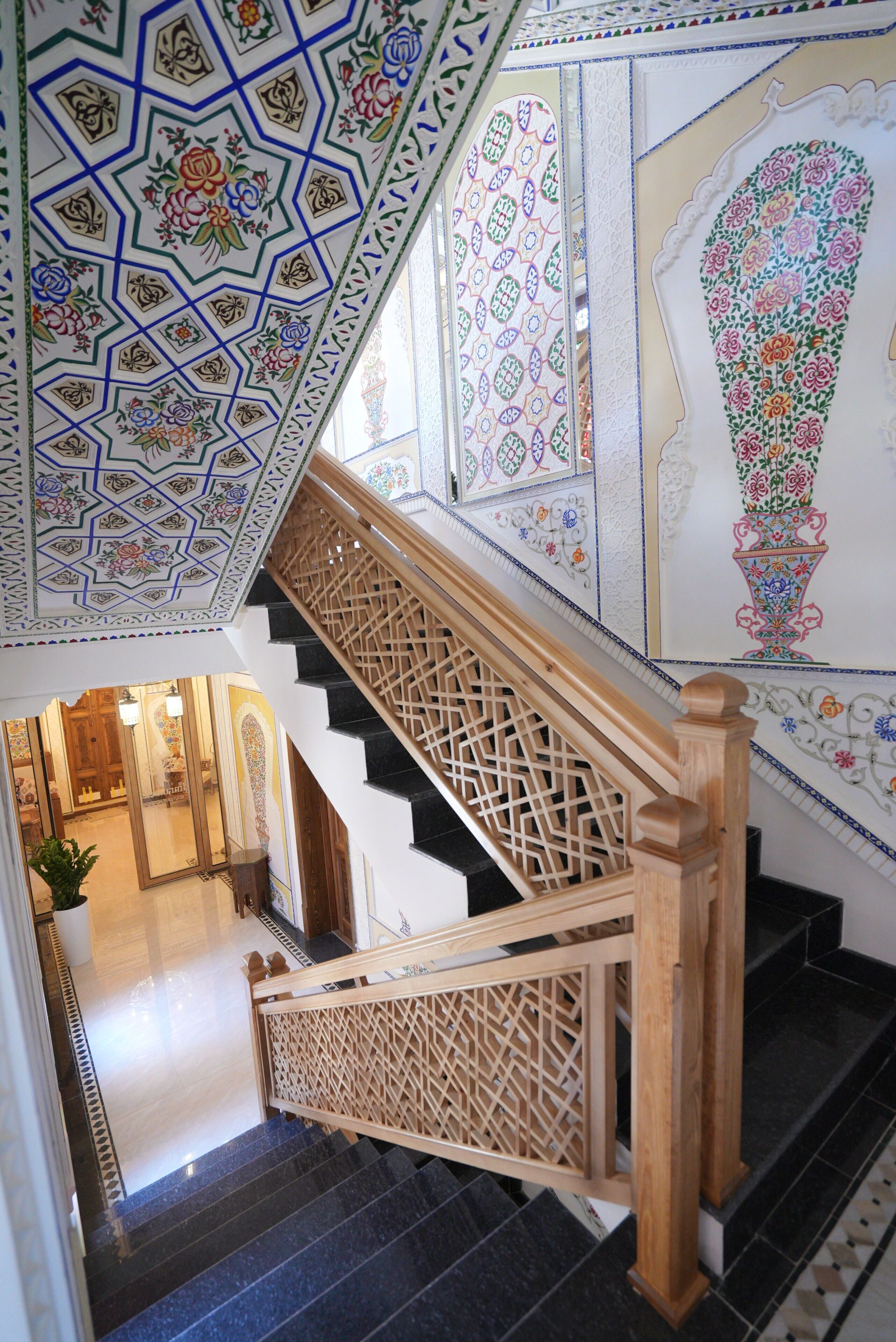Una escalera con elaborados diseños de azulejos y barandilla de madera.