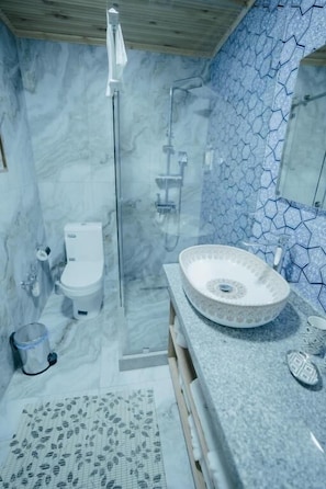 A bathroom with a glass shower enclosure, a white toilet, and a large, round sink with a decorative basin. - Imranbek Boutique Hotel (Bukhara)