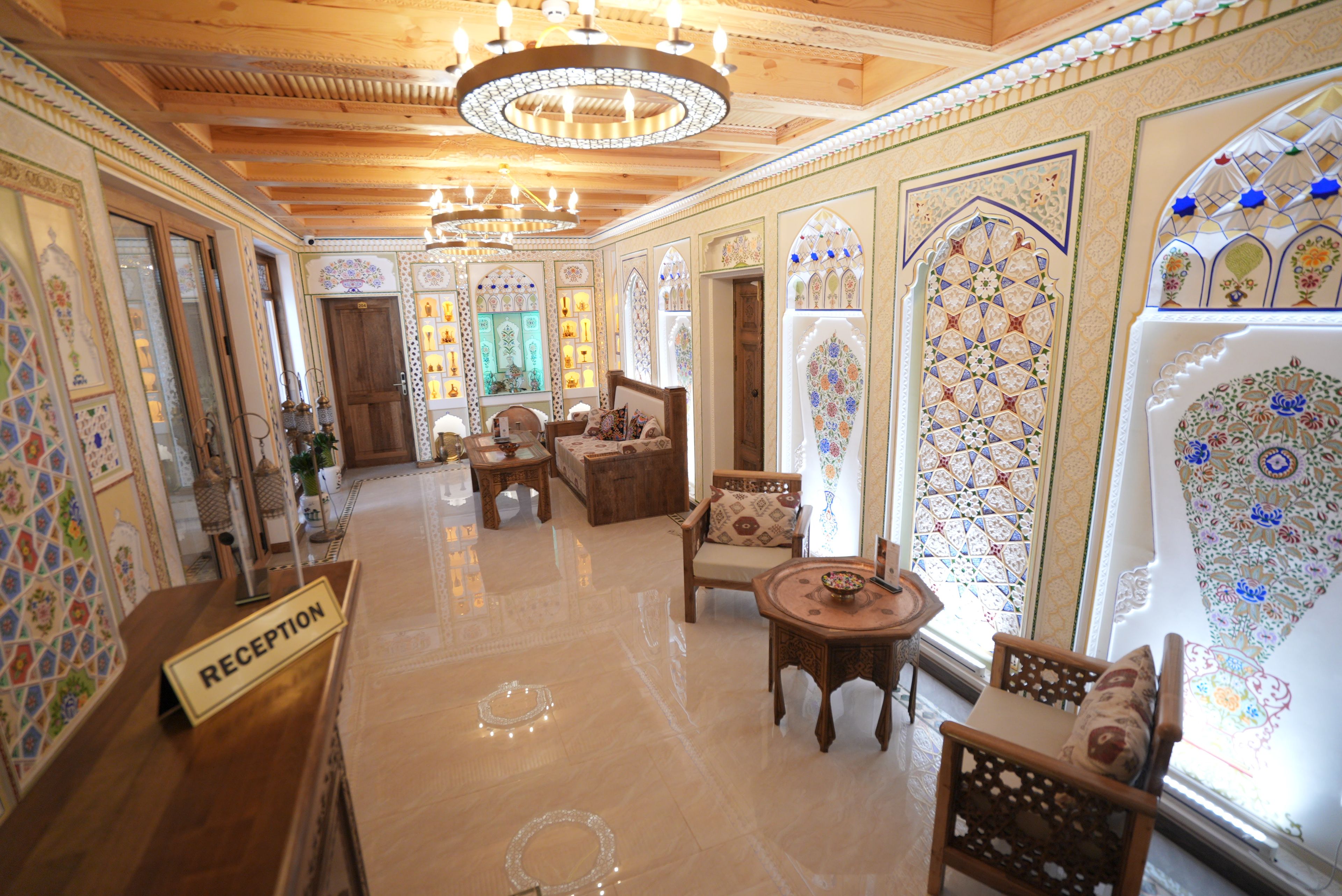 A reception area with a sign, a reception desk, and a seating area with chairs and a table.
