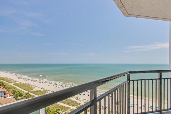 Ein Balkon mit Blick auf Strand und Meer.
