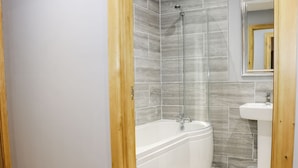 Ein Badezimmer mit Badewanne, Dusche und Waschbecken.