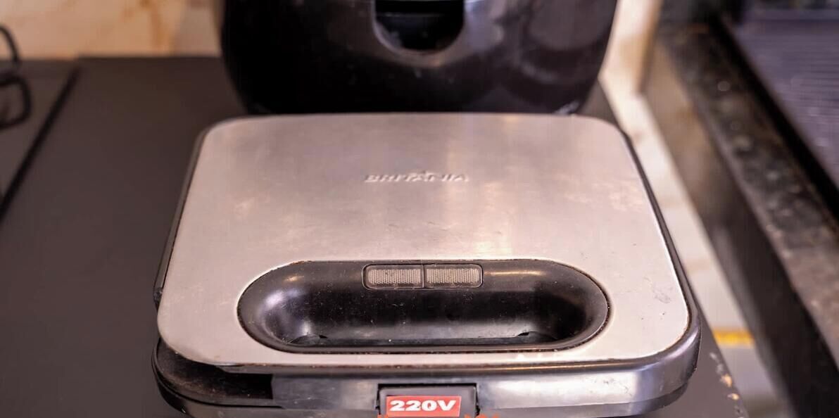Metallinen esine, jossa on 220 V:n merkintä ja kytkin.