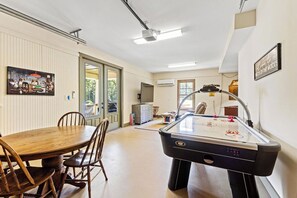A dining area with a wooden table and chairs, a pool table, and a painting on the wall. - New! 2 home property on Lake Martin, sleeps 12! (Dadeville)