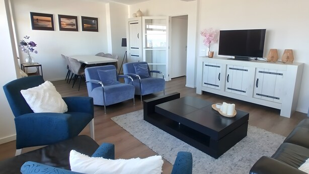 A modern living room with a sofa, chairs, a coffee table, a TV, and a cabinet. - Apartment 'ViewRoyal' with Sea View, Balcony and Wi-Fi (Katwijk)