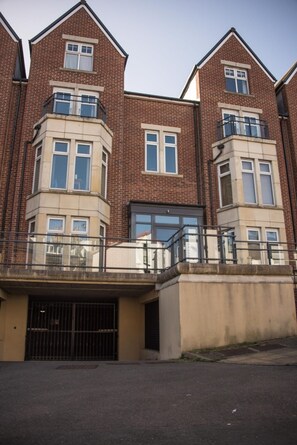 A multi-story residential building with a brick facade, large windows, and a gated entrance. - Pinot Perch - With Free Underground Parking (Whitby)