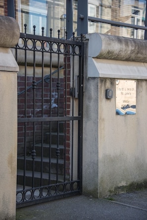 A gated entrance with a metal gate and a brick wall. - Pinot Perch - With Free Underground Parking (Whitby)
