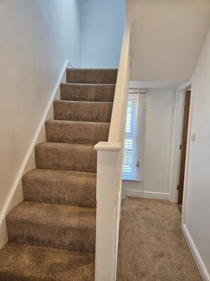 A carpeted staircase with white handrails leading to a landing. - Salt Sage - Whitby (Whitby)