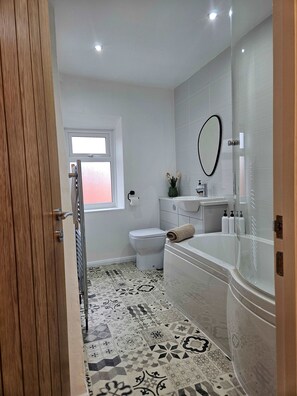 Un bagno moderno con servizi igienici, lavabo e vasca da bagno.