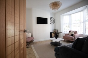 A modern living room with a sofa, a coffee table, and a TV mounted on the wall. - Sea Renity - Whitby (Whitby)