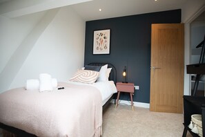 A bedroom with a bed, bedside table, and a door. - Sea Renity - Whitby (Whitby)