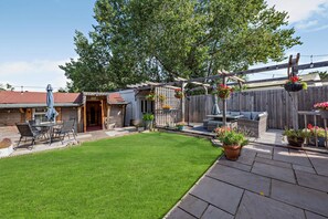 A backyard with a patio, a barbecue area, and a hanging flower basket. - Host Stay Thornbank (Chichester)