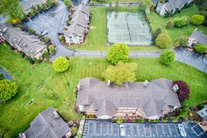 A residential area with houses, a tennis court, and a parking lot. - Cardinal 104 at Chetola: Updated 2br Ground Floor Condo with Wood Burning Fireplace (Blowing Rock)