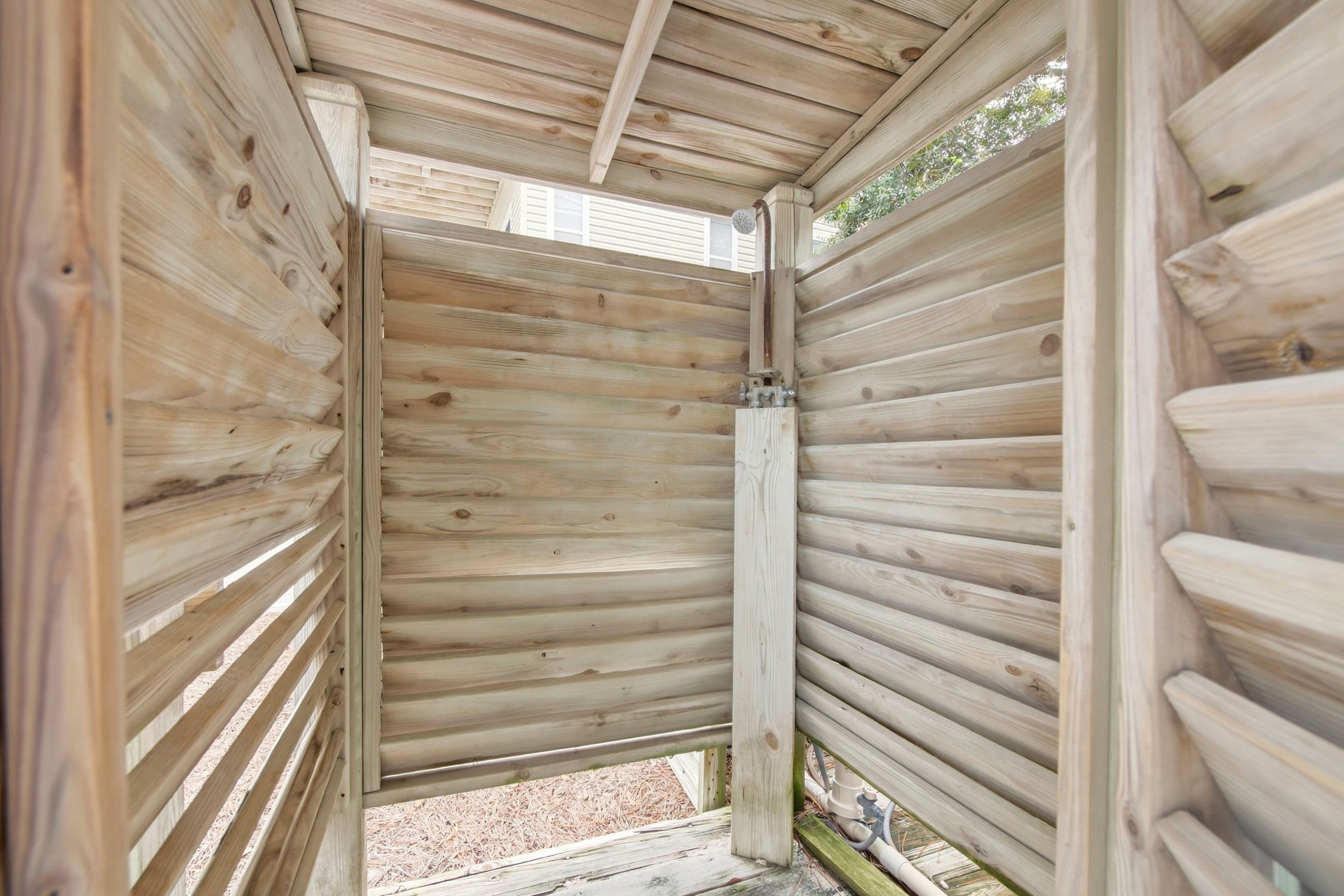Un intérieur en bois avec des lambris horizontaux, un cadre de porte apparent et une petite fenêtre.