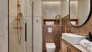 Ein modernes Badezimmer mit einer gläsernen Dusche, einer weißen Toilette und einem Holzkosmetikschrank mit einem großen Spiegel.