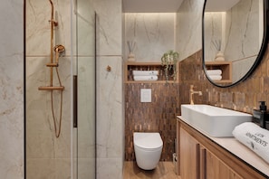 A modern bathroom with a glass-enclosed shower, a white toilet, and a wooden vanity with a large mirror. - Perspektywa Apartment with balcony (Gdańsk)