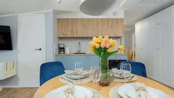 A modern kitchen with wooden cabinets, a coffee maker, and a sink.