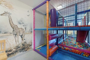 A play area with a ball pit, slides, and a giraffe mural. - Air Conditioned Apartment with Balcony | Parking (Mielno)