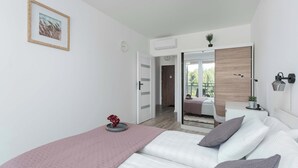 Un dormitorio moderno con cama, mesita de noche y espejo.