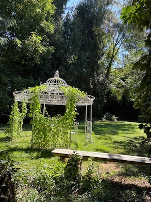 A gazebo with a lattice roof and a bench in a lush garden. - Bed and Breakfast 'La Bertiniere' with Shared Terrace, Shared Garden and Wi-Fi (Nazelles-Négron)