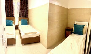A hotel room with two beds, a small bedside table, and a nightstand. - Schiller 14 :  3 Bedrooms Apart Munich City Center (München)