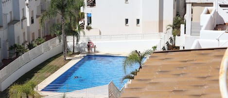 A swimming pool with a white building in the background.