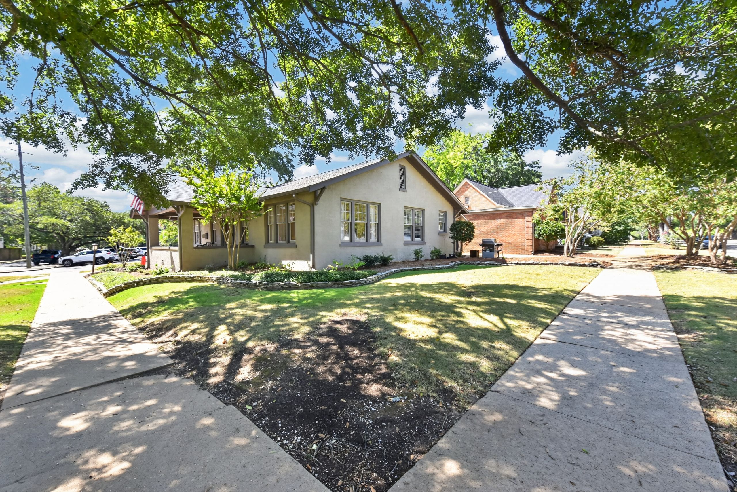 A residential house with a front yard, a driveway, and a sidewalk.