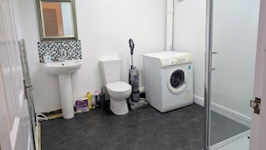 Un baño con inodoro, lavamanos y lavadora.