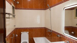 A bathroom with a toilet, bathtub, and sink. - OrbitNet HJ (Madinah)