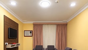 Una habitación de hotel con un conjunto de sofá, una televisión y una mesita.