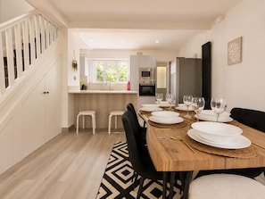 A modern kitchen with a dining area set for six. - Perfect Booking Bright 3 Bed Home w Garden Sunroom (Ascot)