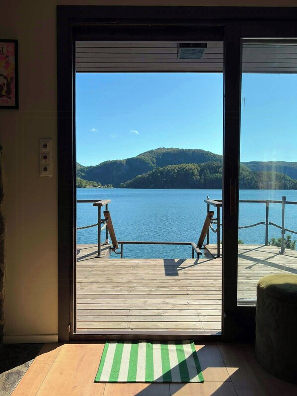 A wooden deck with a view of a lake and hills.