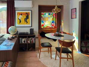 A cozy living room with a dining area, a bookshelf, a globe, and a stained glass window. - Retro beach house with jetty in Åptafjorden (Farsund)