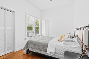 A bedroom with a bed, a window, and a wardrobe. -  2-bedroom Lake Worth Beach House; Near Downtown (Lake Worth Beach)