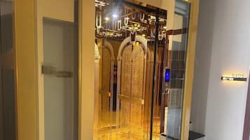 An elevator with a golden interior and a digital display.