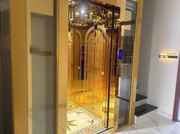 An elevator with a golden interior and a digital display.