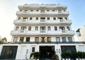 A multi-story hotel with a prominent sign indicating it is the 'Khai Nguyen Hotel'.