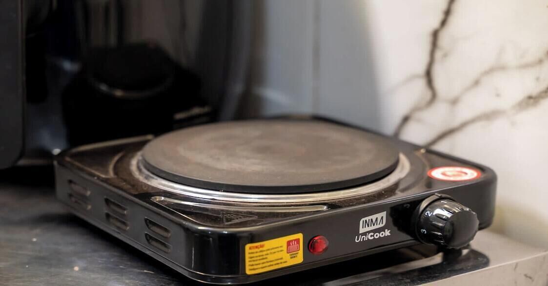 Una cocina de inducción portátil con una perilla de control y un botón de encendido.