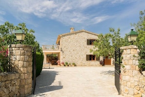 A stone building with a covered patio and a gated entrance. - Scenic Country Haven With Pool (Pollença)