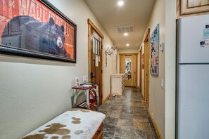 A narrow hallway with a bench, a refrigerator, and a door leading to another room. - Closest Ski-in/out Condo at Northstar Village (Truckee)